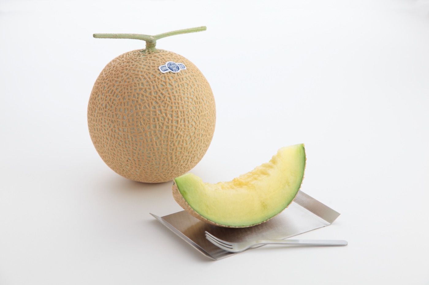 A cut Crown Melon revealing its ripe green flesh